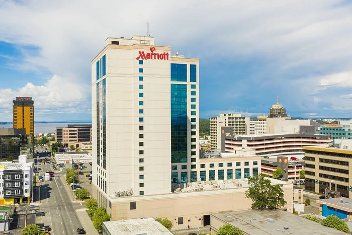 Marriott Anchorage Downtown hotel exterior view showcasing the building's modern architecture and prominent signage against a cloudy sky, located in Anchorage, Alaska.